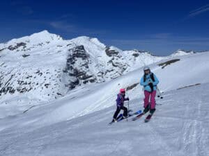 Skier and child enjoying freeriding on snowy mountain slopes in Arlberg.