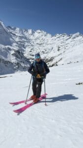 Skier in winter landscape on Arlberg mountain with snow-covered peaks.